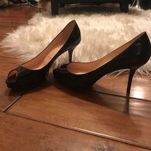 Used Christian Louboutin patent peep- toe pumps.